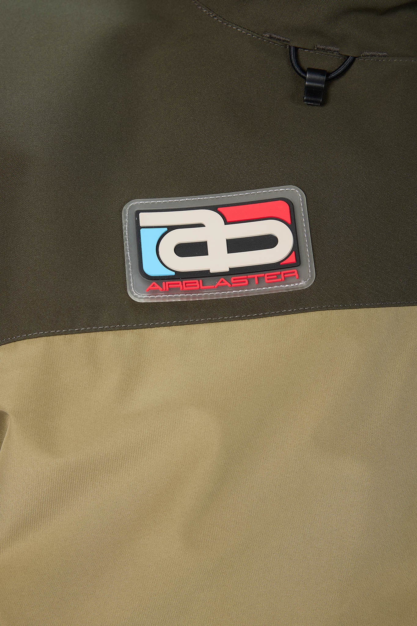 Close-up of a jacket with an Airblaster logo on a green background