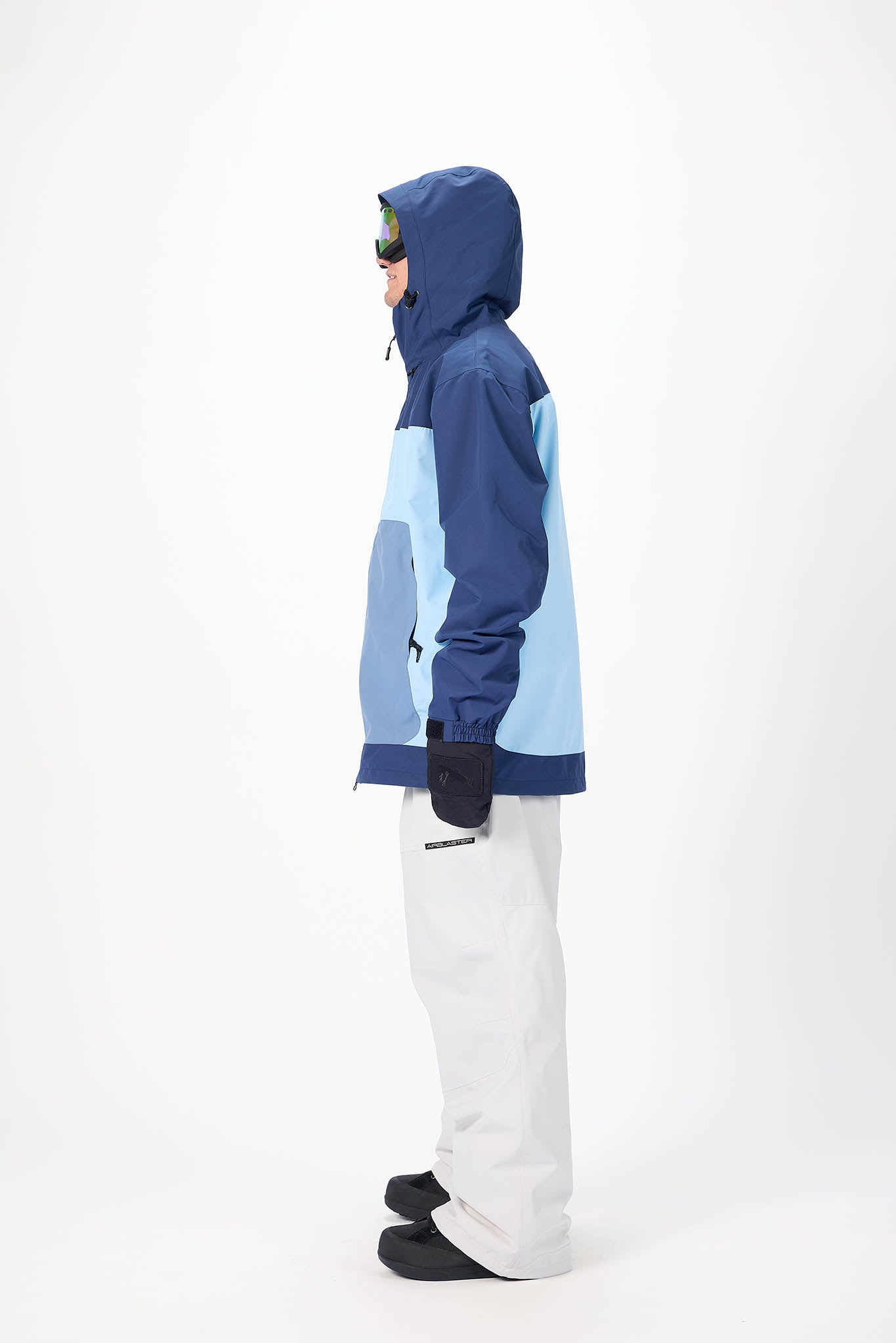 Person wearing a blue and light blue jacket with white pants on a white background