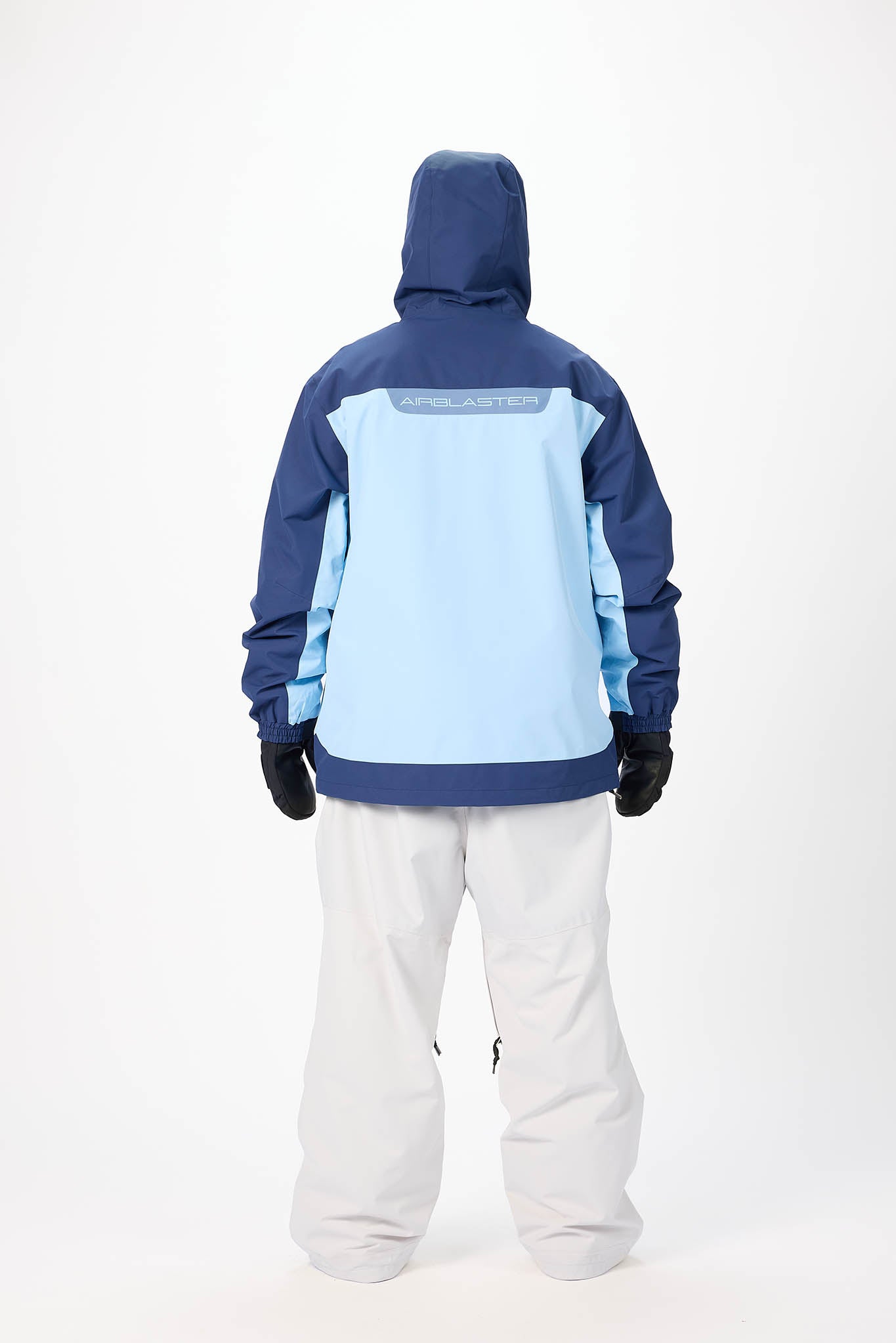Person wearing a blue and light blue jacket with white pants on a white background