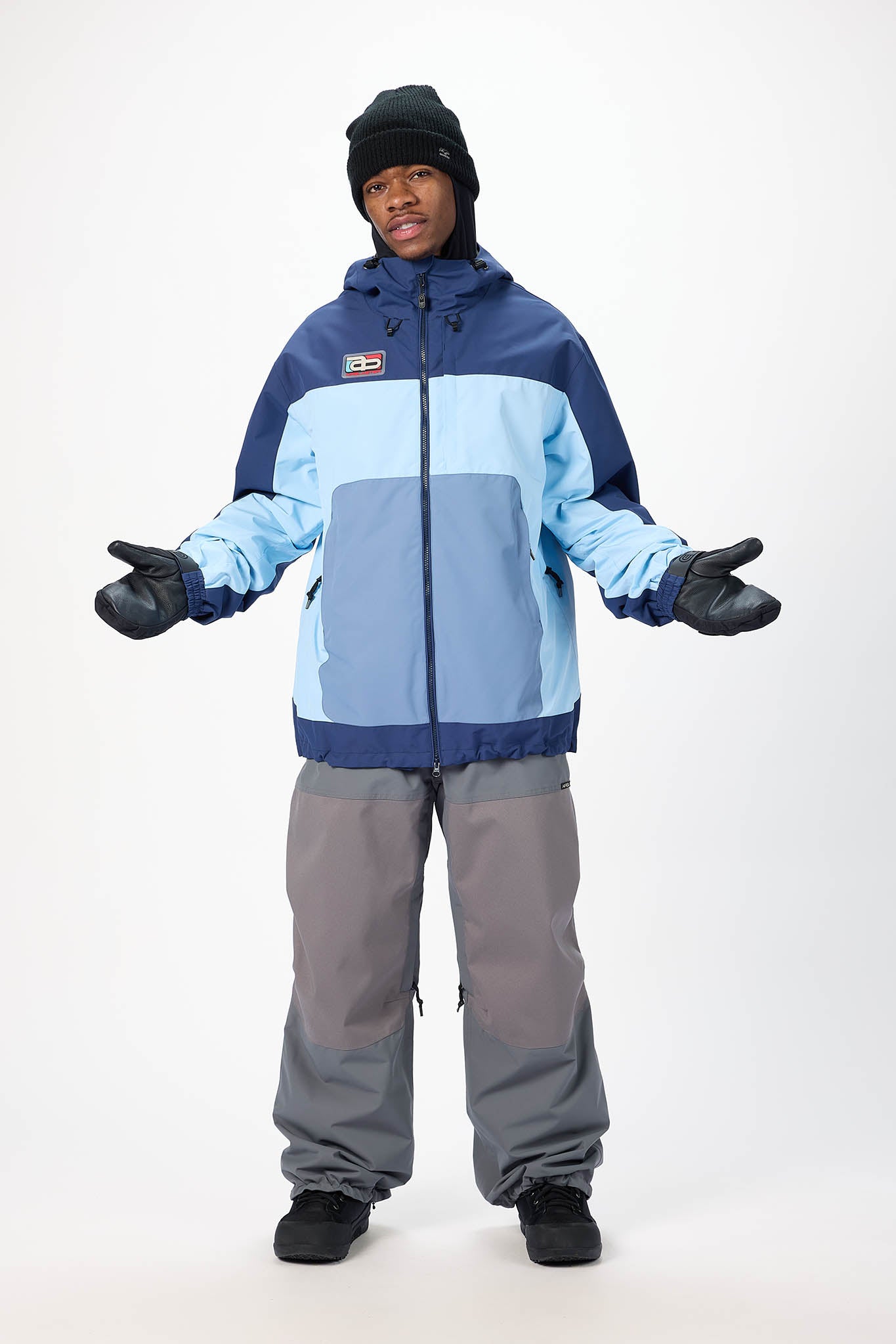 Person wearing a blue and gray snowsuit on a white background