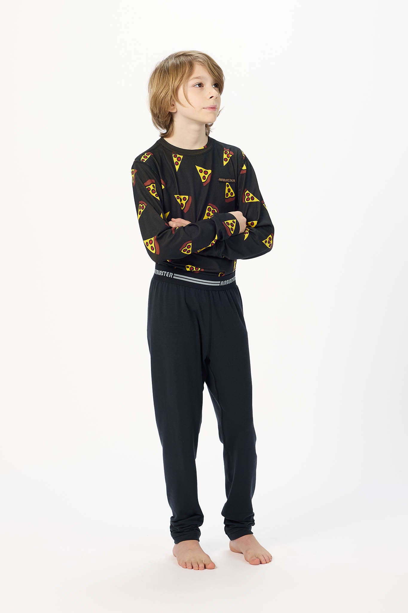 Youth Hero standing center frame, looking away wearing youth black base layer bottoms with white background. 