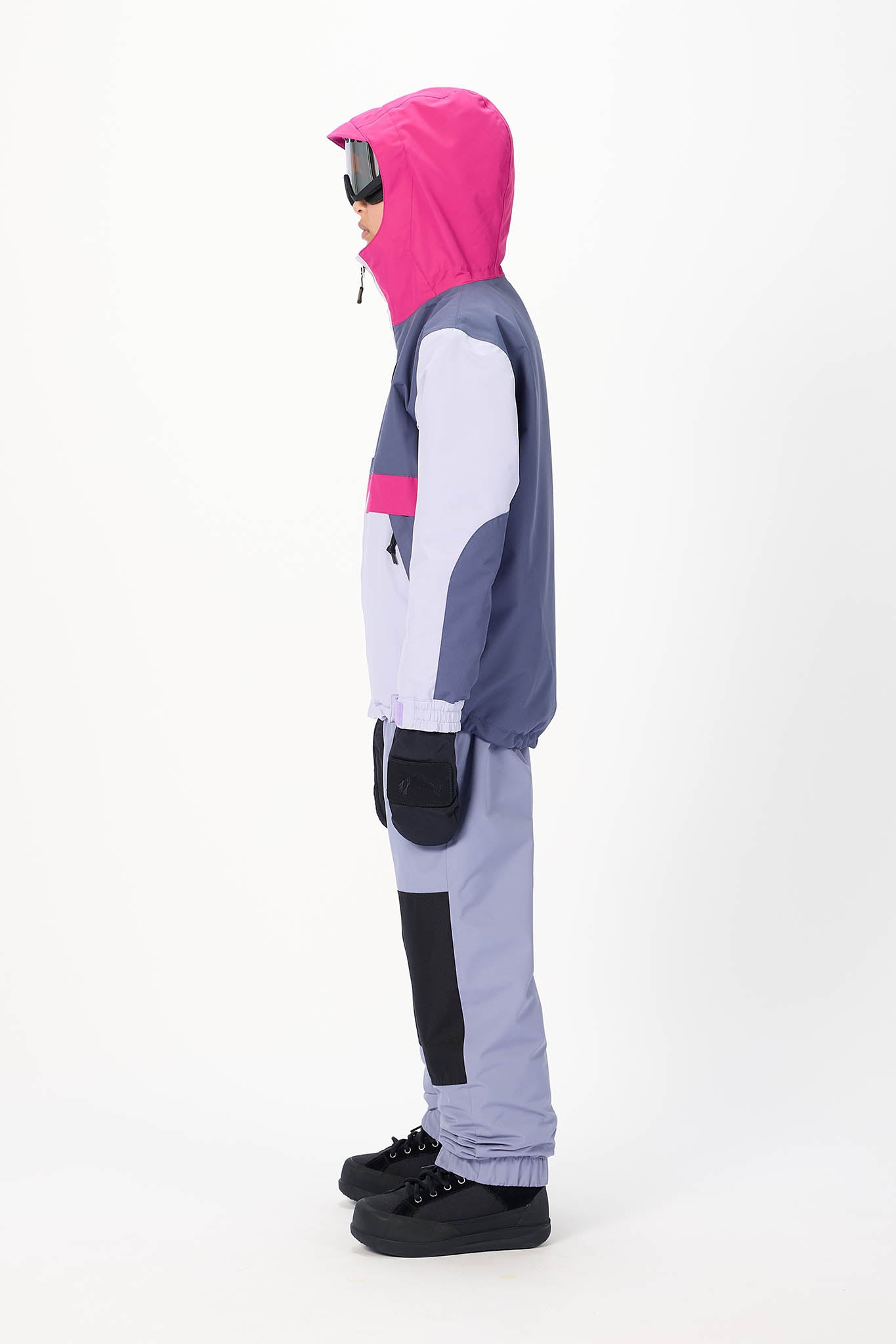 A child model shown in profile wearing a color-blocked hooded jacket and matching pants. The jacket features a bright pink hood, navy blue sleeves, and a light gray body with a pink stripe.
